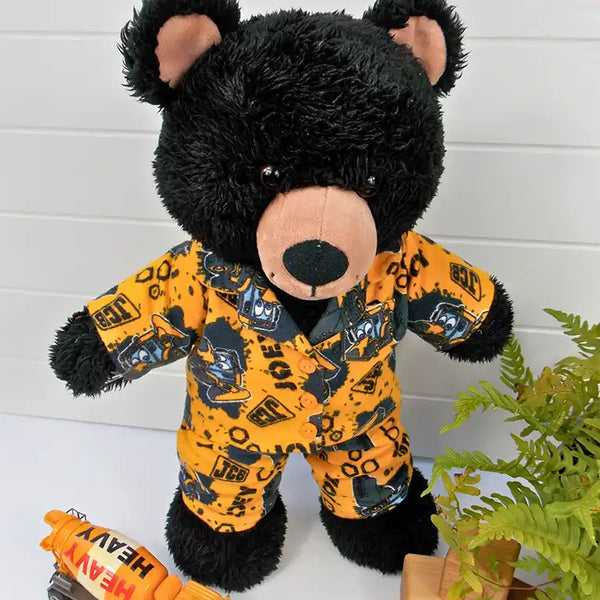 Build a bear teddy bear wearing mustard coloured pyjamas with diggers on them