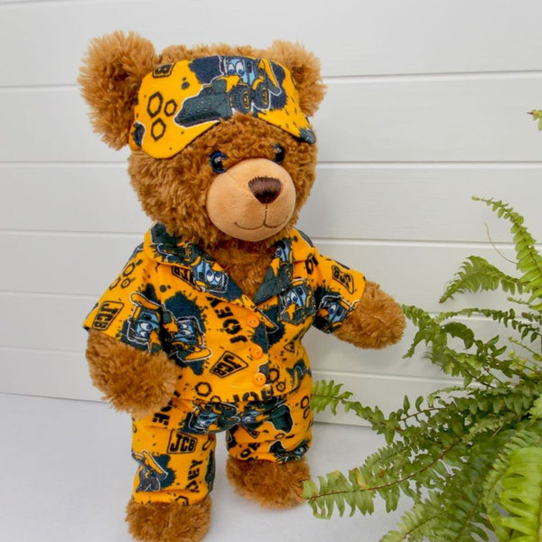 Brown teddy bear wearing pyjamas and a sleep mask